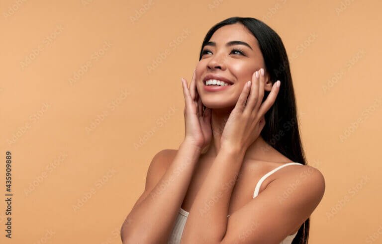 Young Asian woman with clean healthy glowing skin in white top